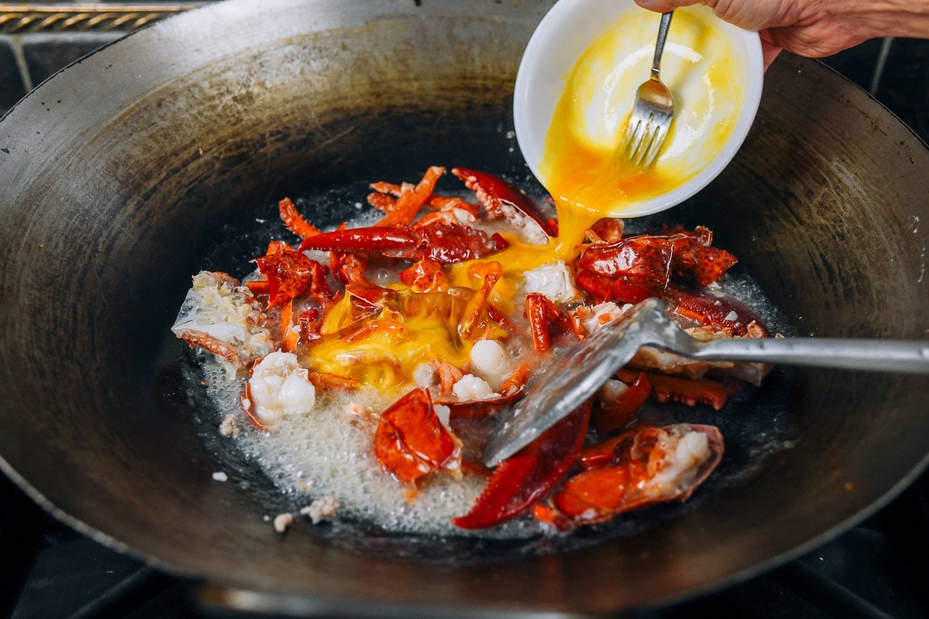 adding egg to lobster in wok