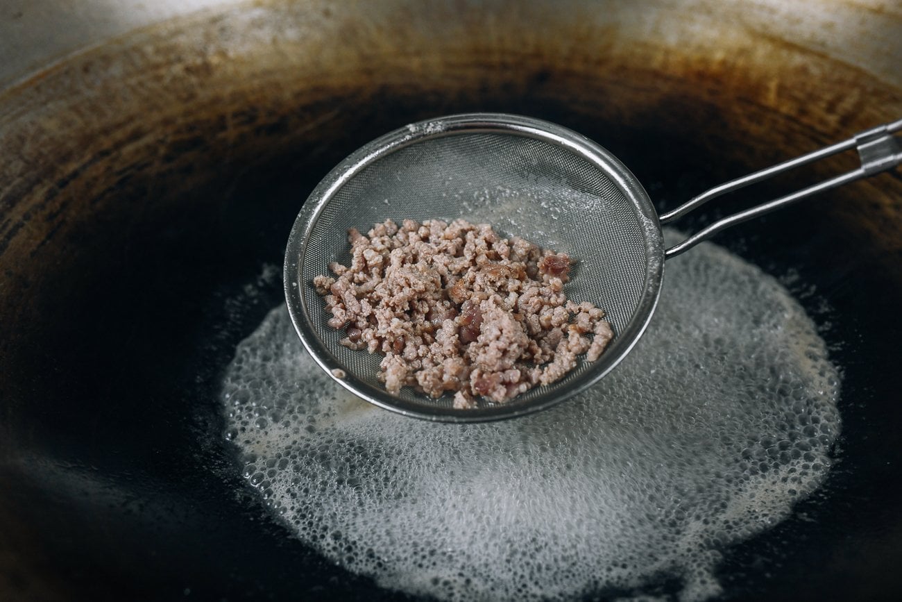cooked ground pork in fine mesh strainer