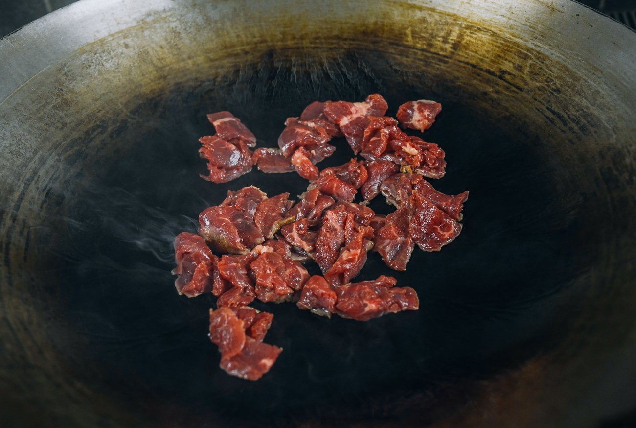 sliced flank steak in wok