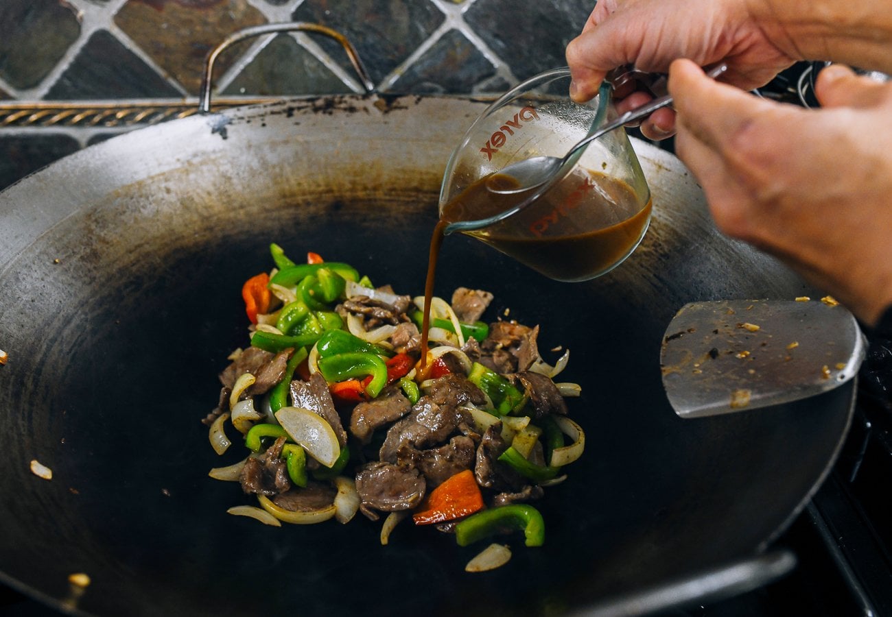 adding sauce to pepper steak and onions