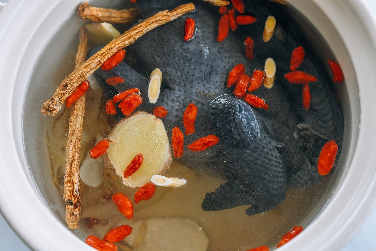 Black Silkie Chicken in soup pot with herbs