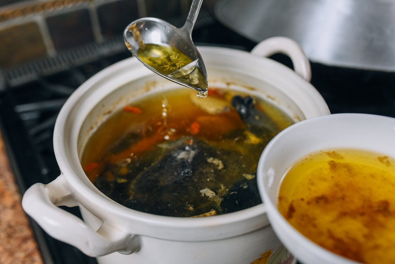 skimming fat off of black chicken soup