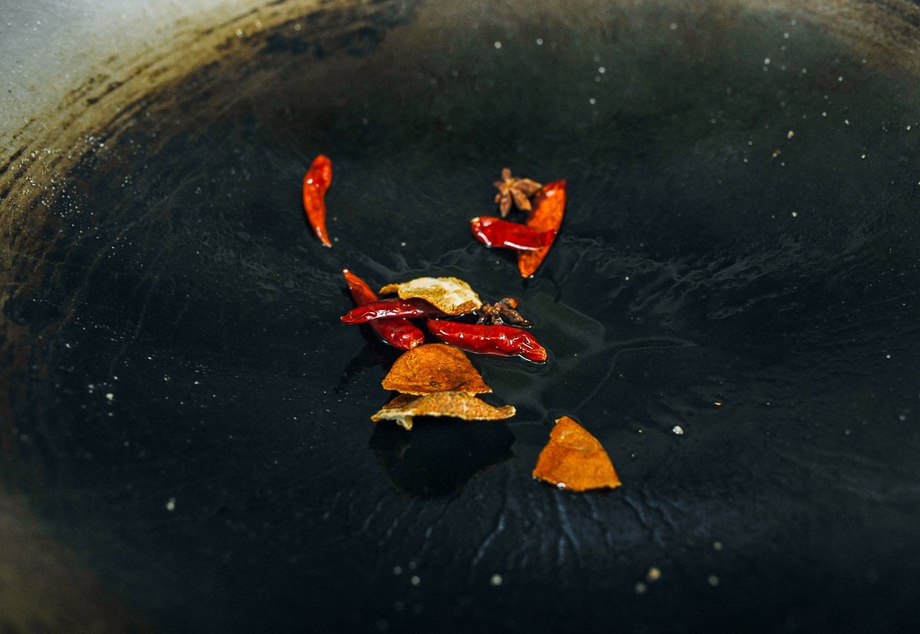 dried tangerine peel, chilies, and star anise in wok