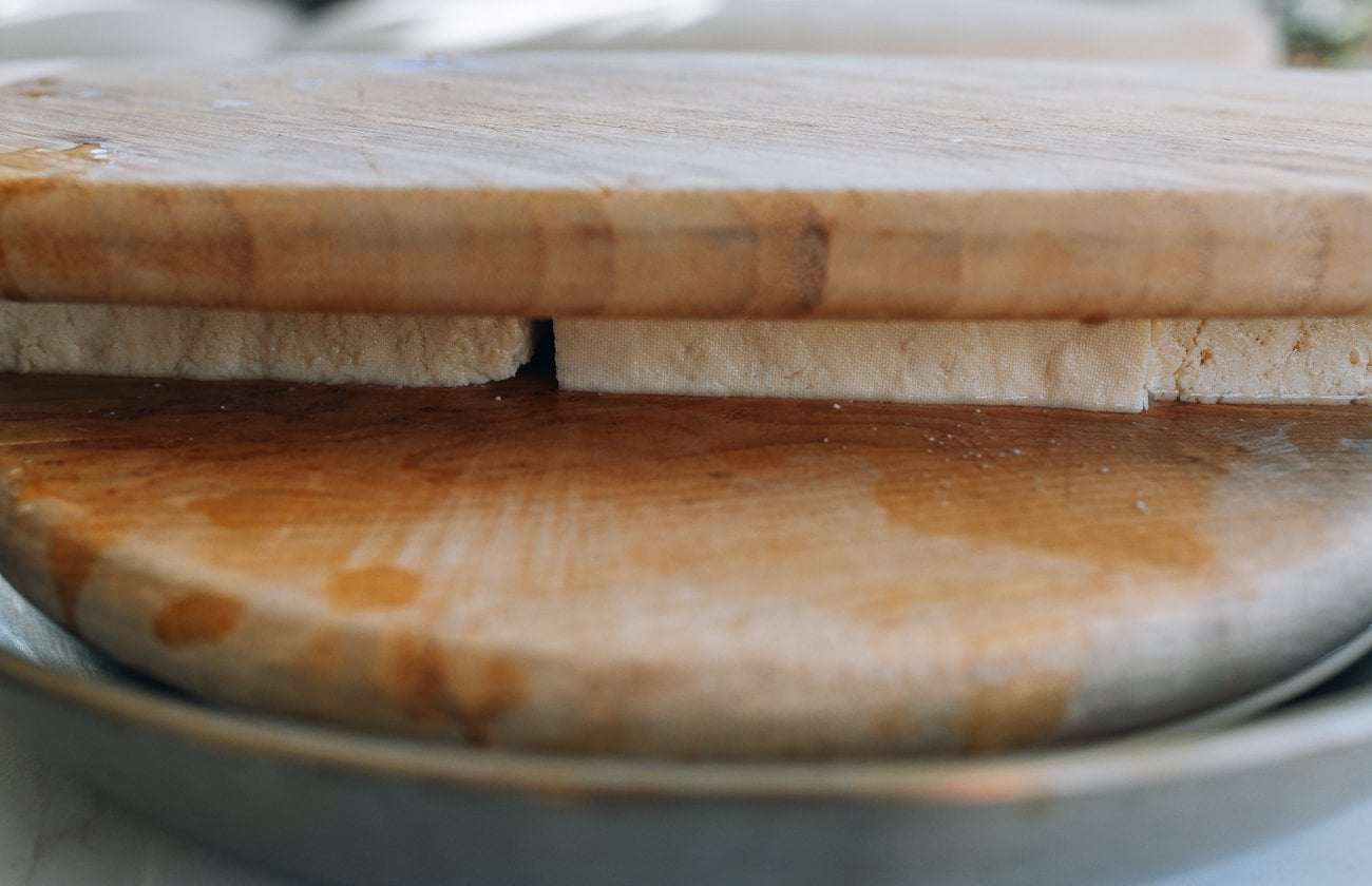 pressing tofu between two cutting boards