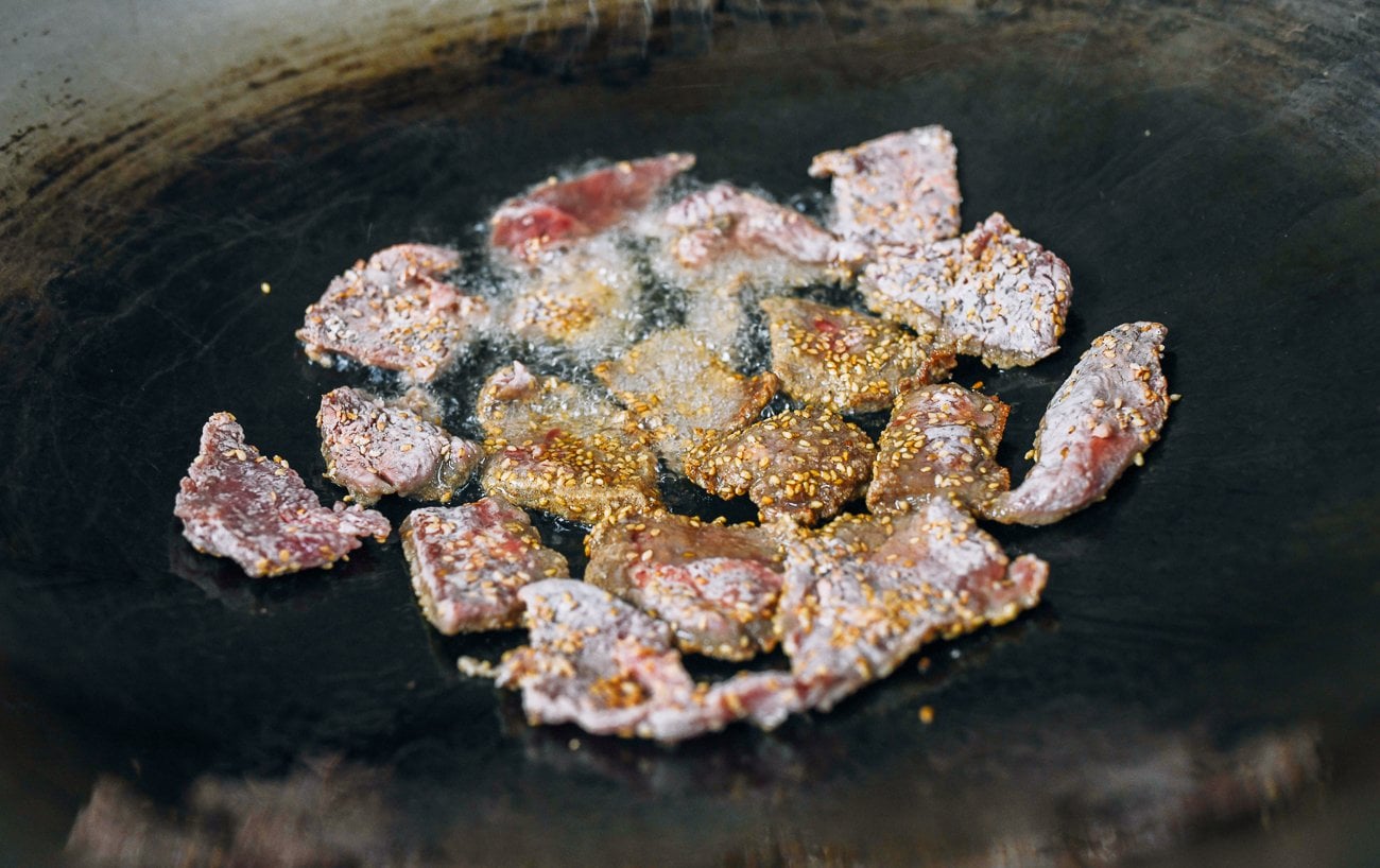 frying dredged beef slices in oil