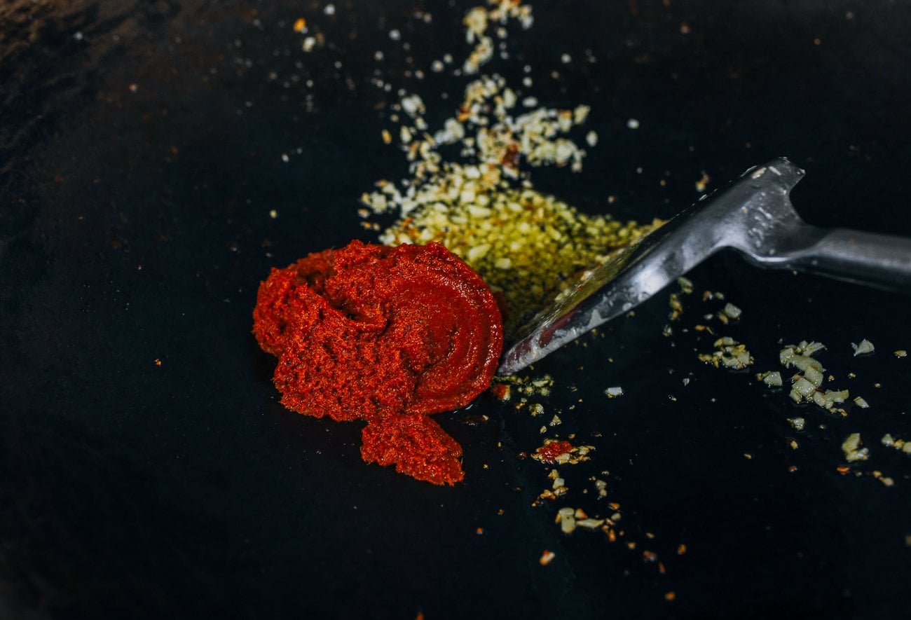 adding Thai red curry paste to garlic and ginger