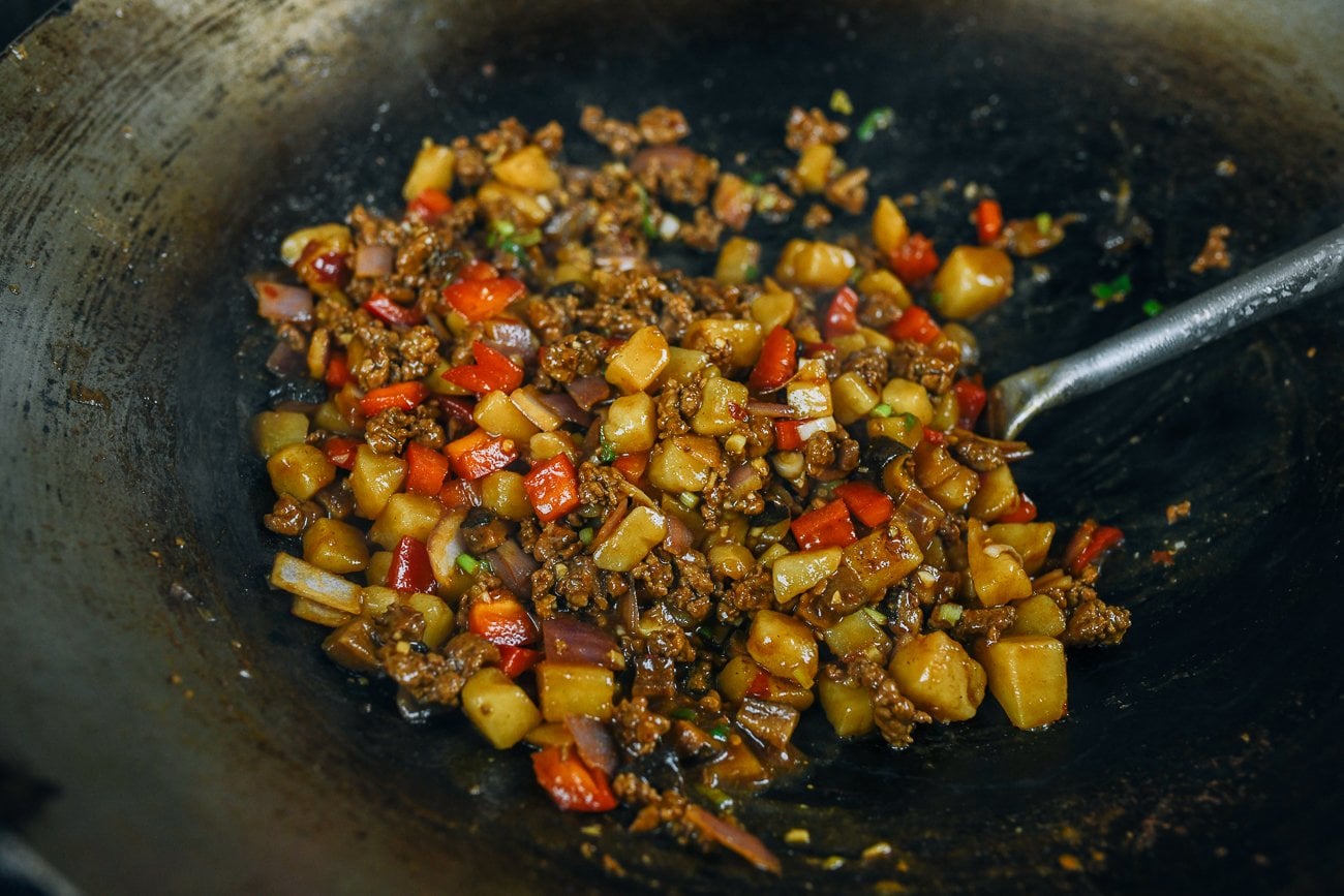finished braised ground pork and potato mixture in wok