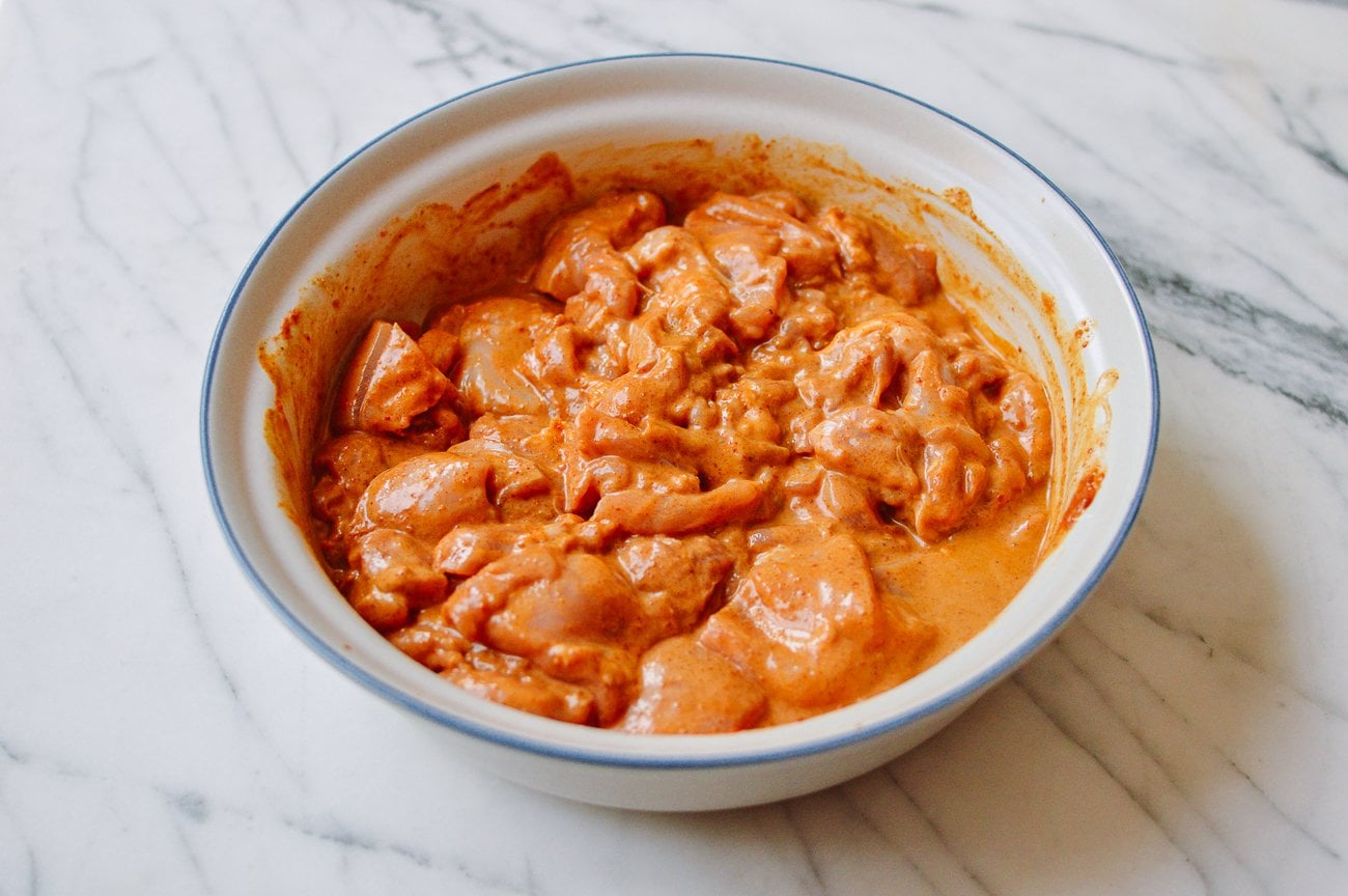 marinating chicken thigh pieces in bowl