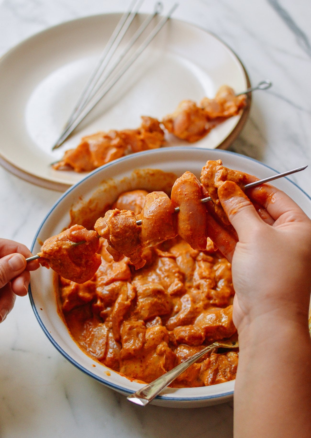 putting chicken on skewers