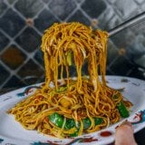 Lifting lo mein out of wok and transferring to serving platter