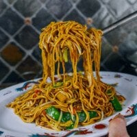 Lifting lo mein out of wok and transferring to serving platter