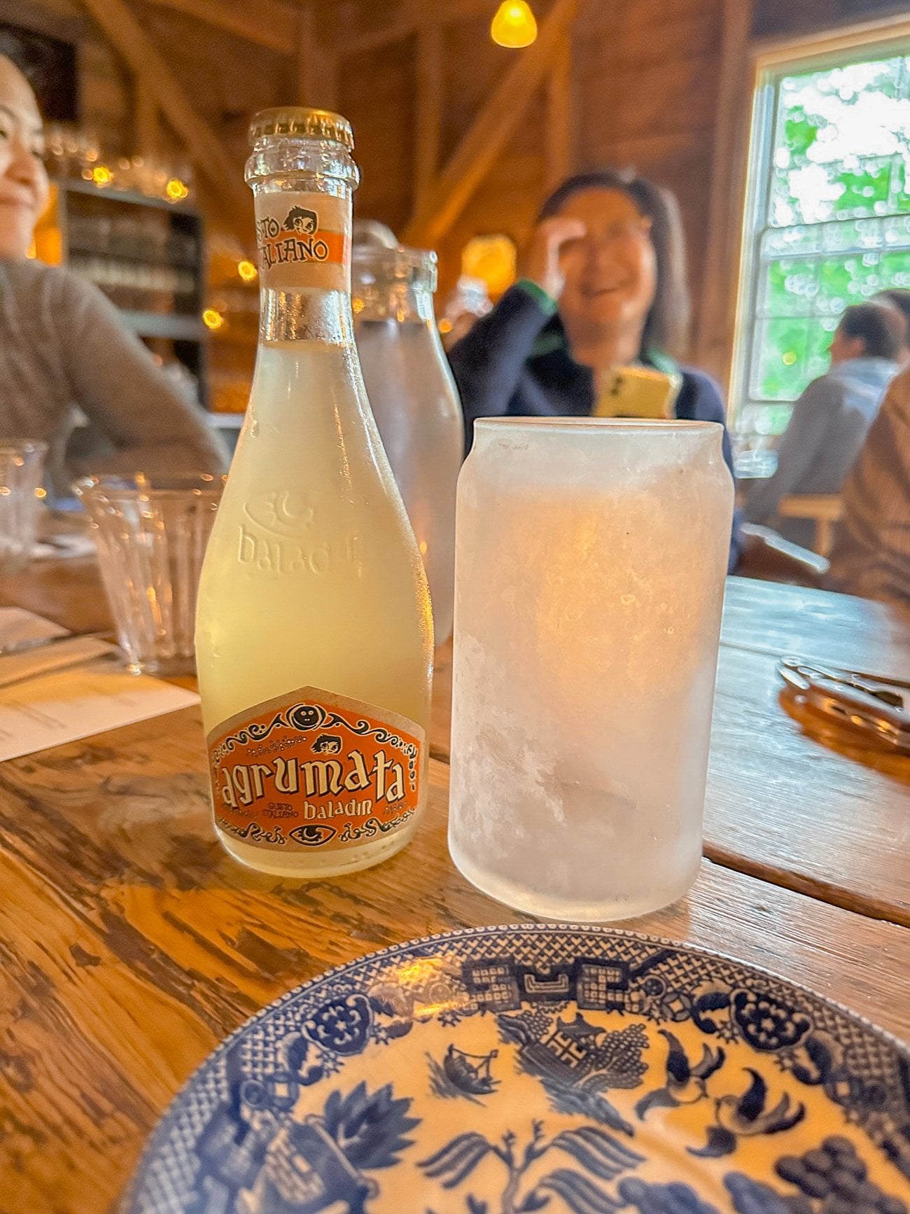 Italian orange soda and a chilled glass with Judy laughing in the background