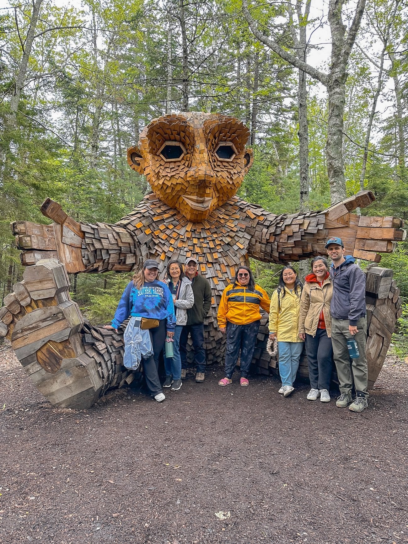 Family photo with a troll made of wood at the Coastal Maine Botanical Garden