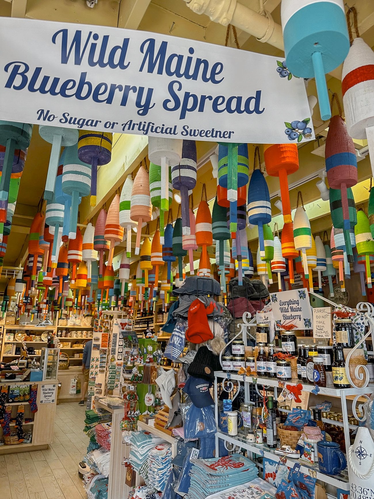 A shop with buoys hanging from the ceiling with a banner for Wild Maine Blueberry Spread