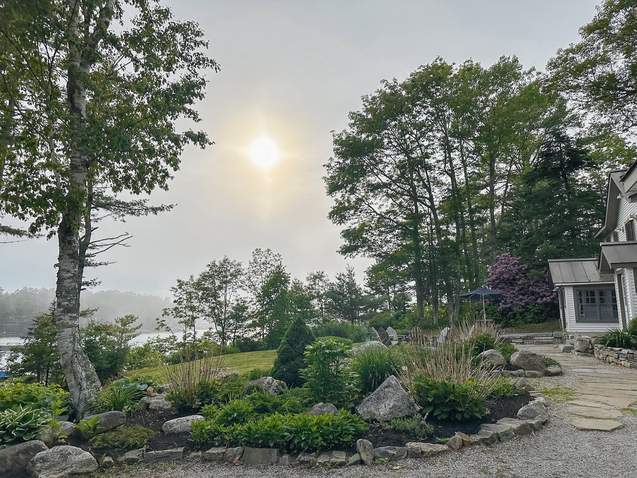 Sun shining over a house and garden in Southport, Maine