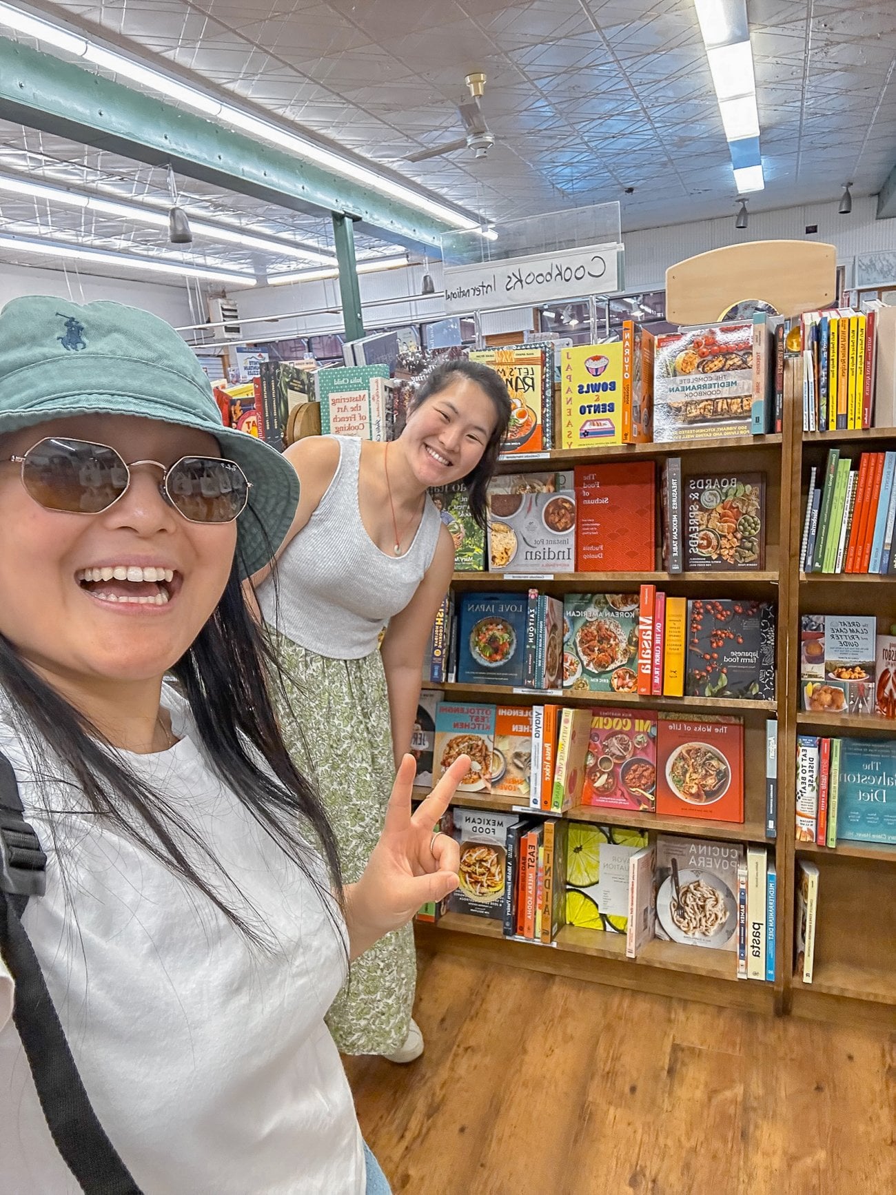 Sarah and Kaitlin at Sherman's Bookstore smiling in the cookbook section