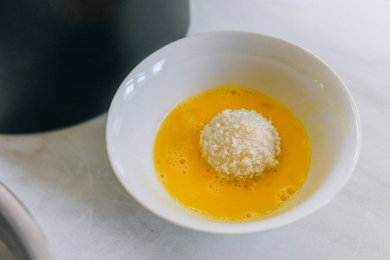 rolling coated tang yuan in beaten egg