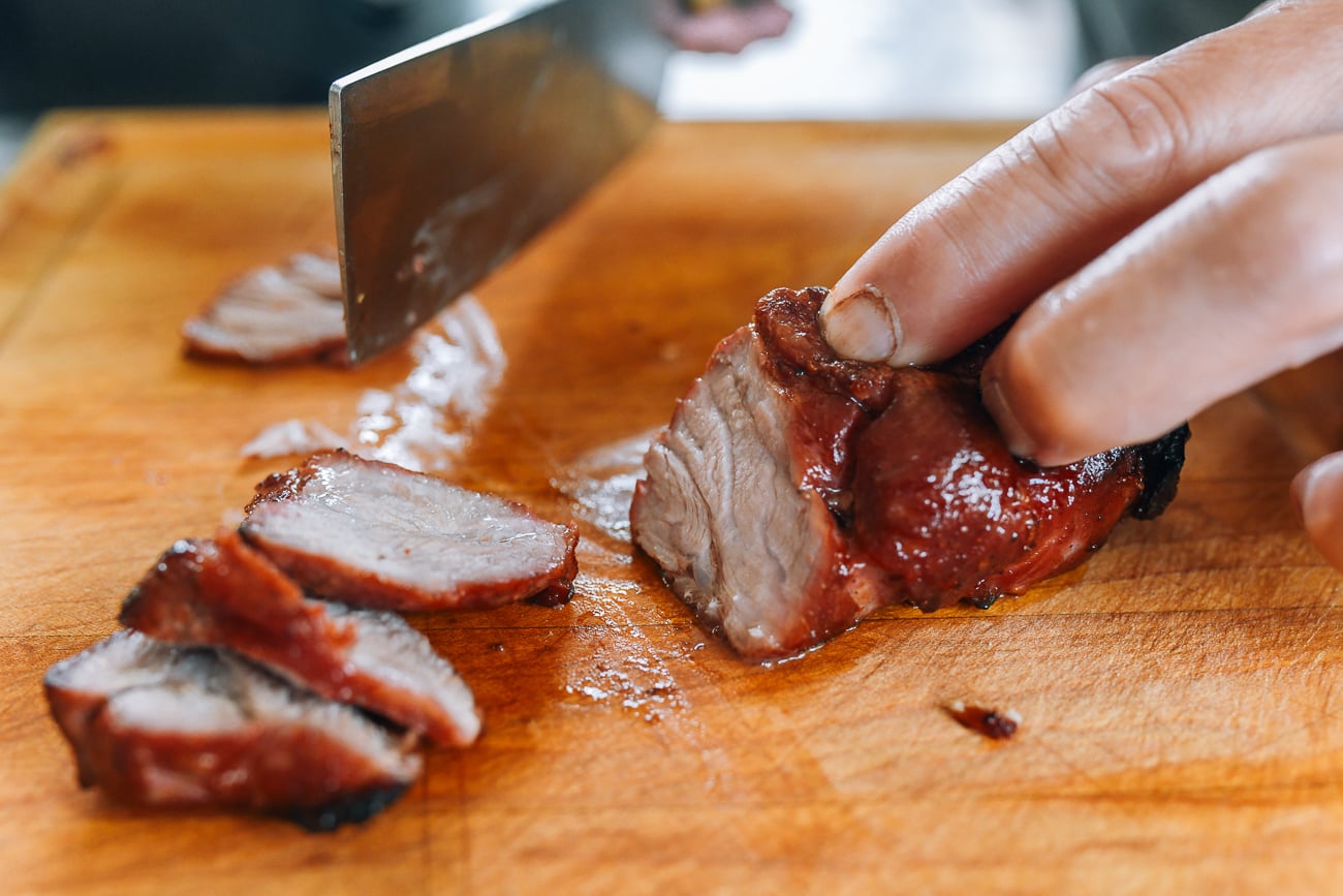 slicing air fryer char siu on a cutting board