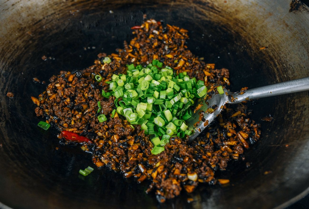 adding scallion greens to meat sauce