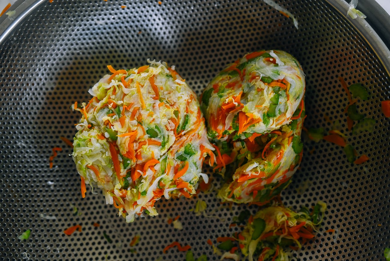blanched shredded vegetables with liquid squeezed out in colander