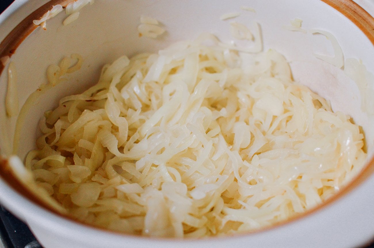 onions cooking in ceramic pot