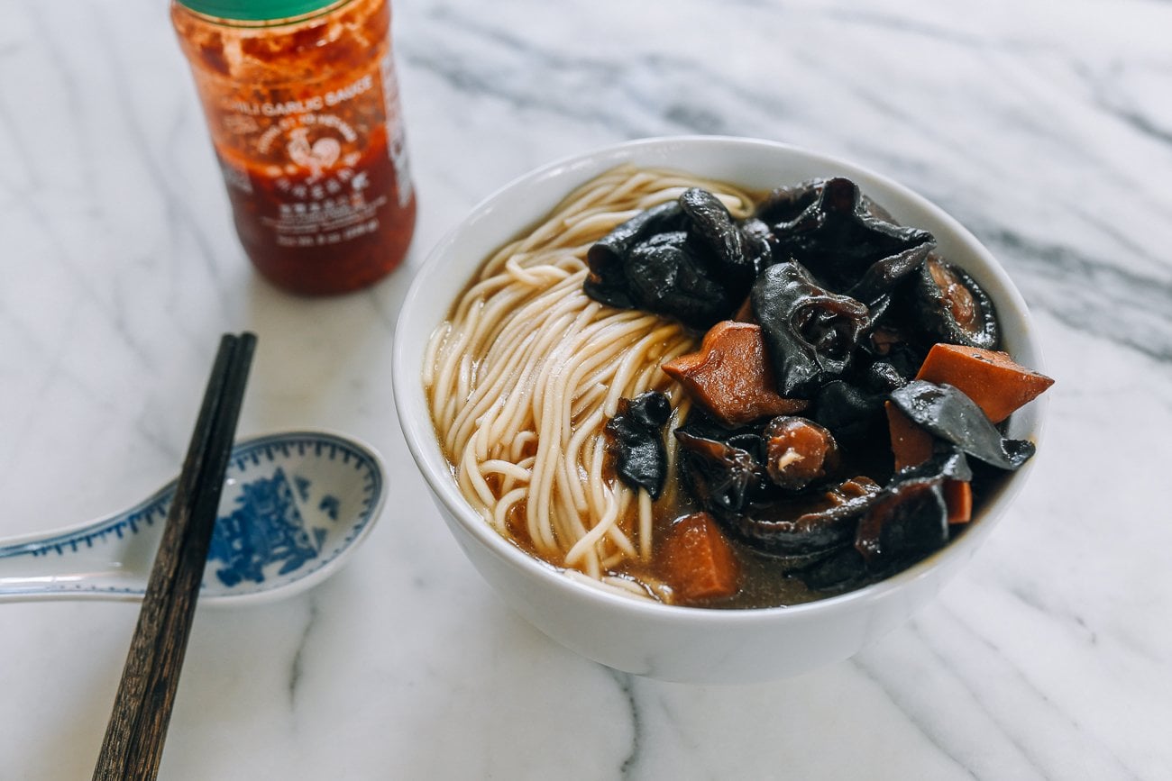 Bowl of mushroom noodle soup with chili garlic sauce