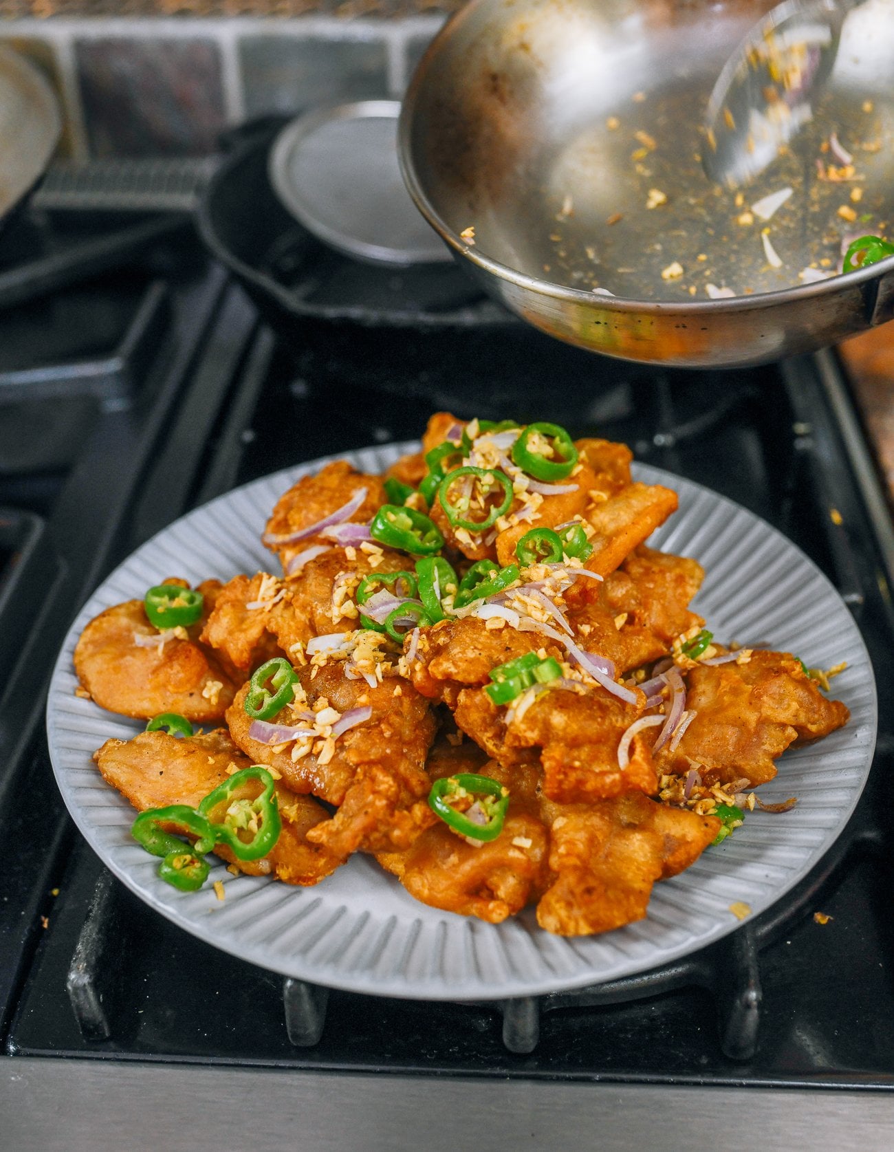 Pouring relish over salt and pepper chicken