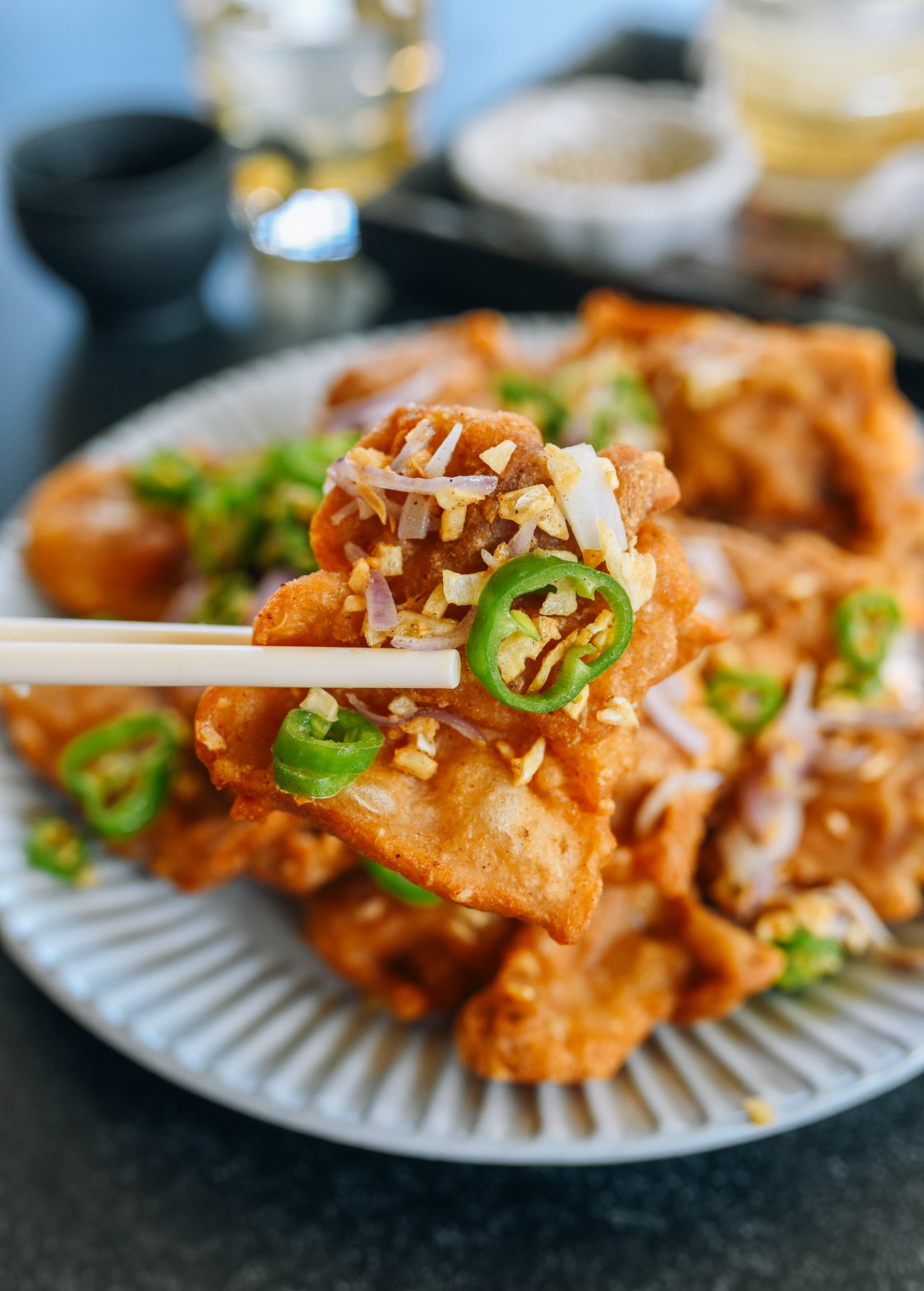 picking up a piece of salt and pepper chicken with chopsticks