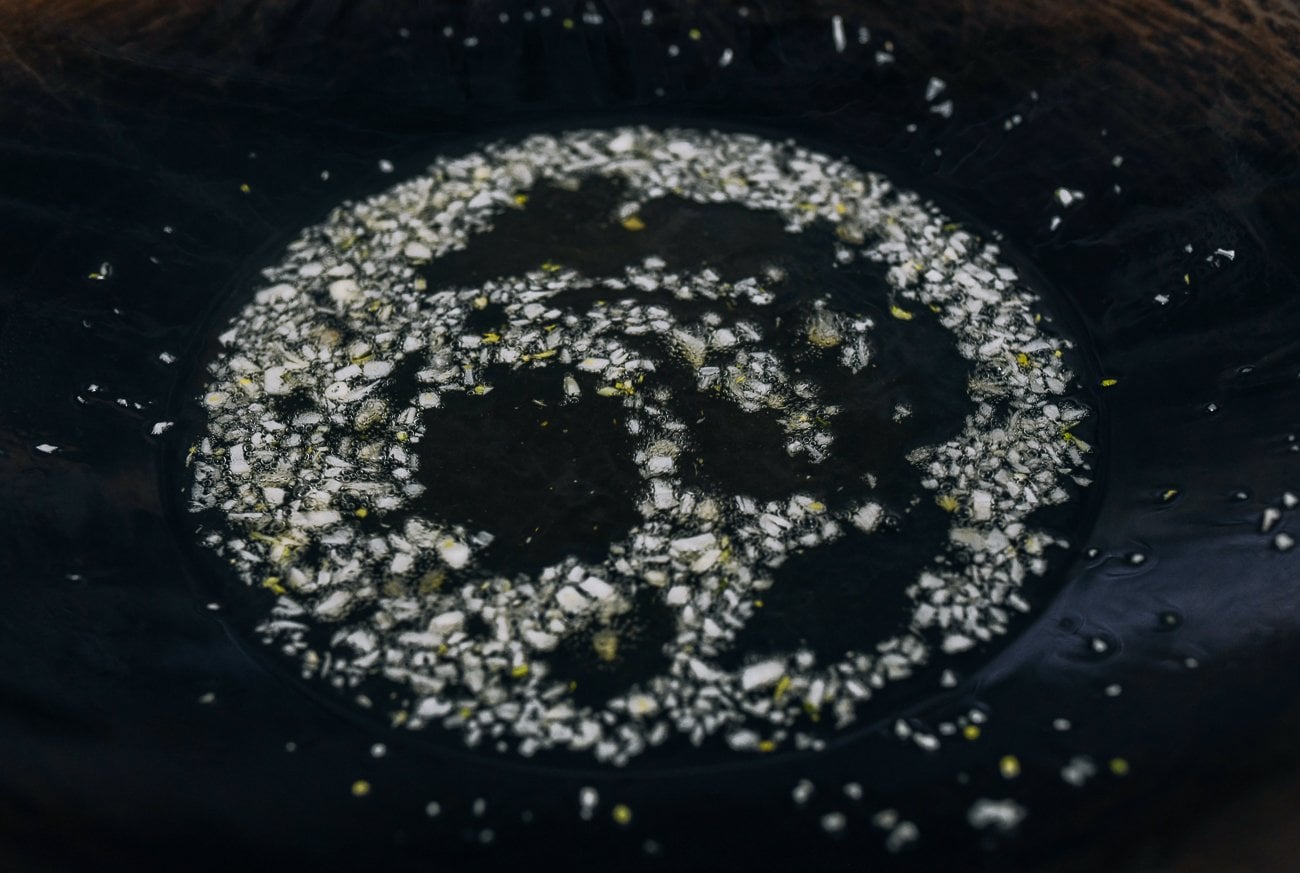 frying chopped garlic pieces in wok