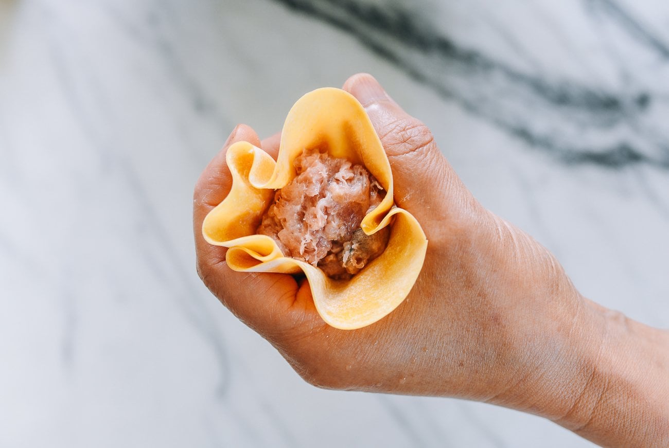 squeezing wrapper around siu mai filling
