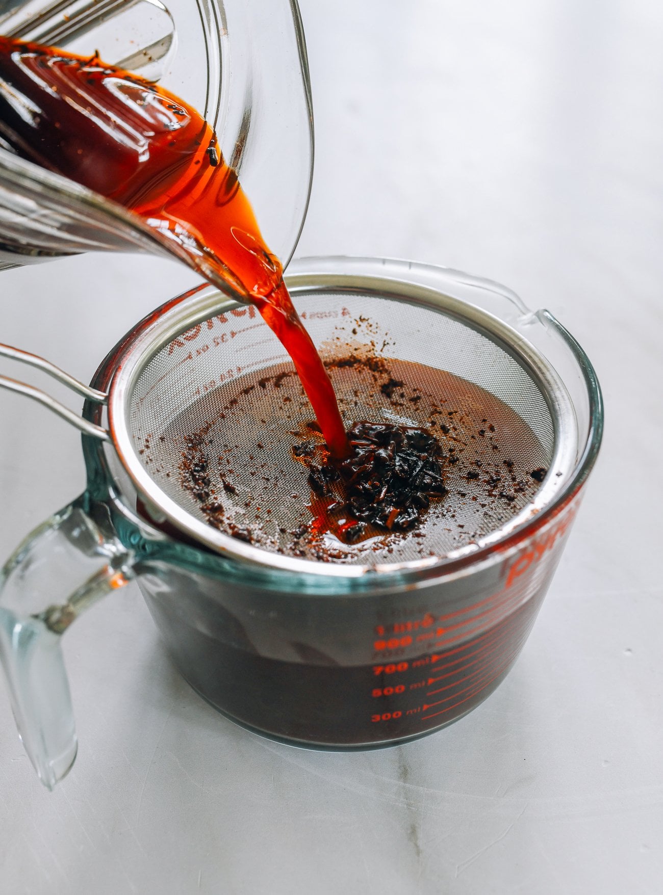 Straining thai tea into measureing cup