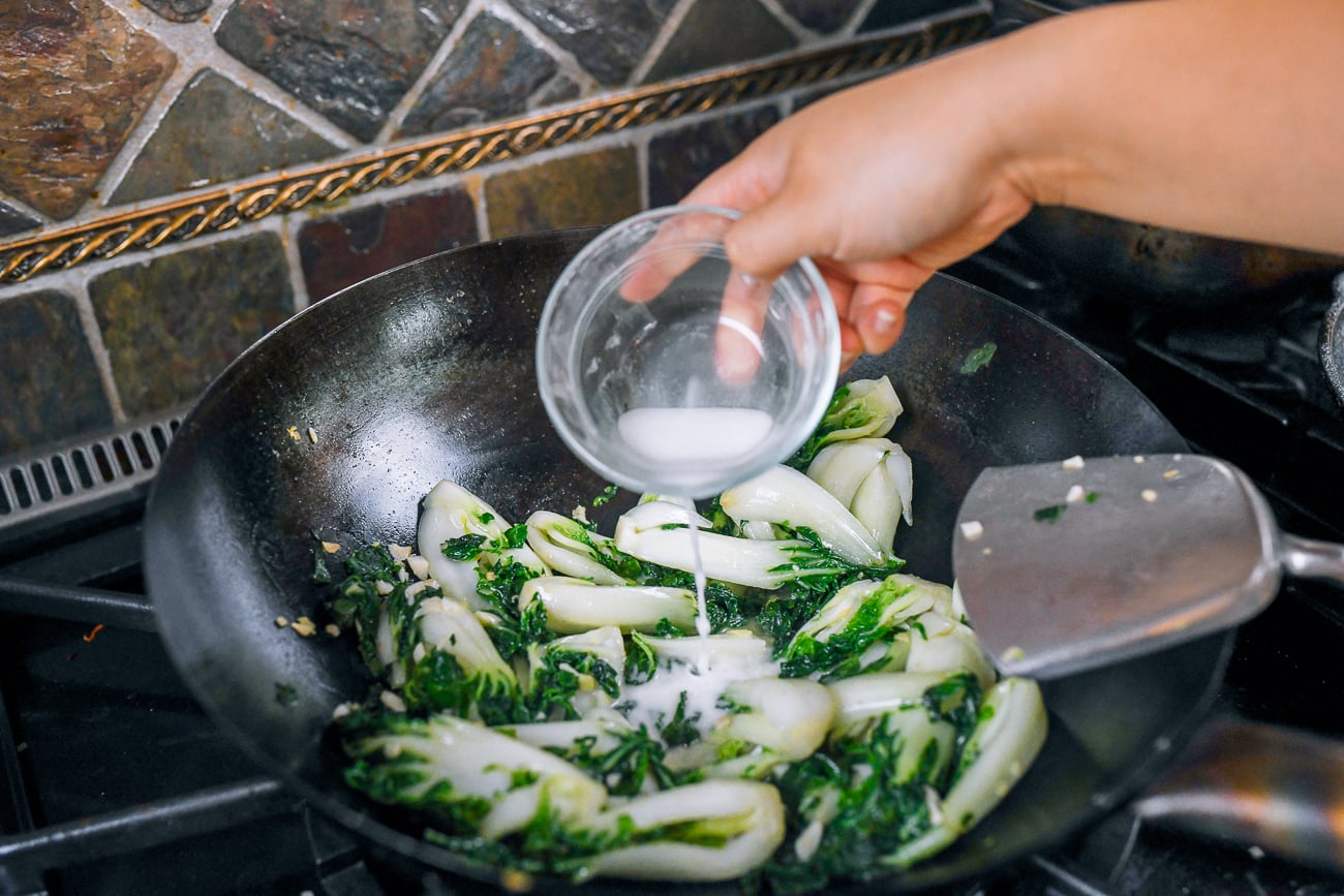 adding cornstarch slurry to bok choy stir-fry