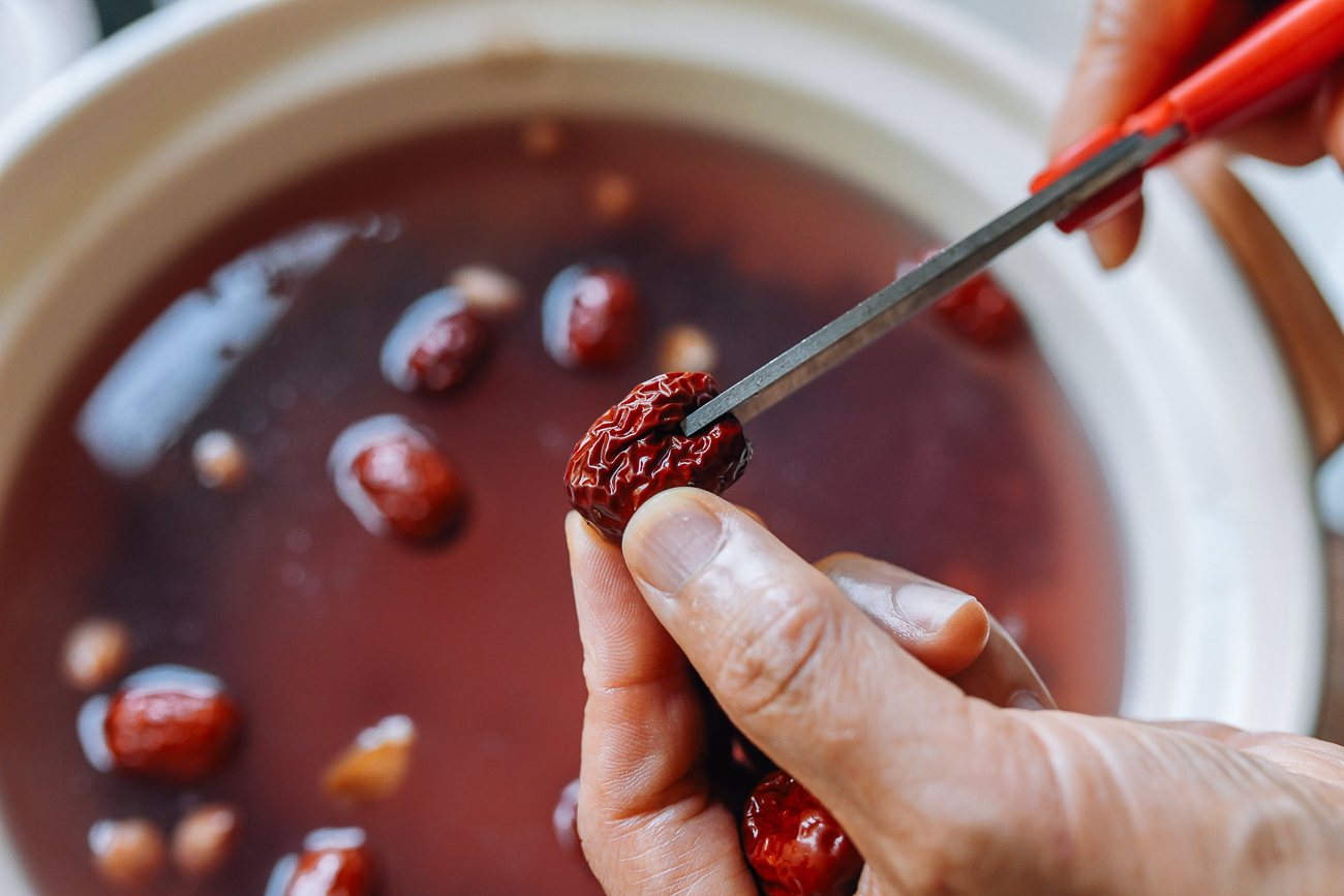 cutting pit out of chinese red date with kitchen shears