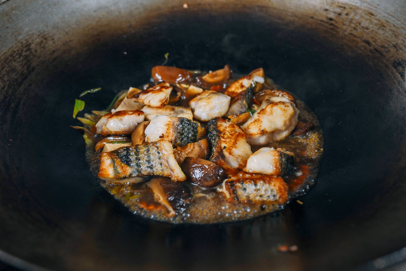 fish addd to vegetables in wok