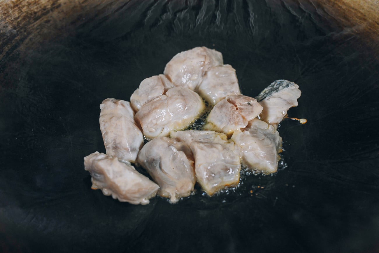 marinated fish pieces in hot wok