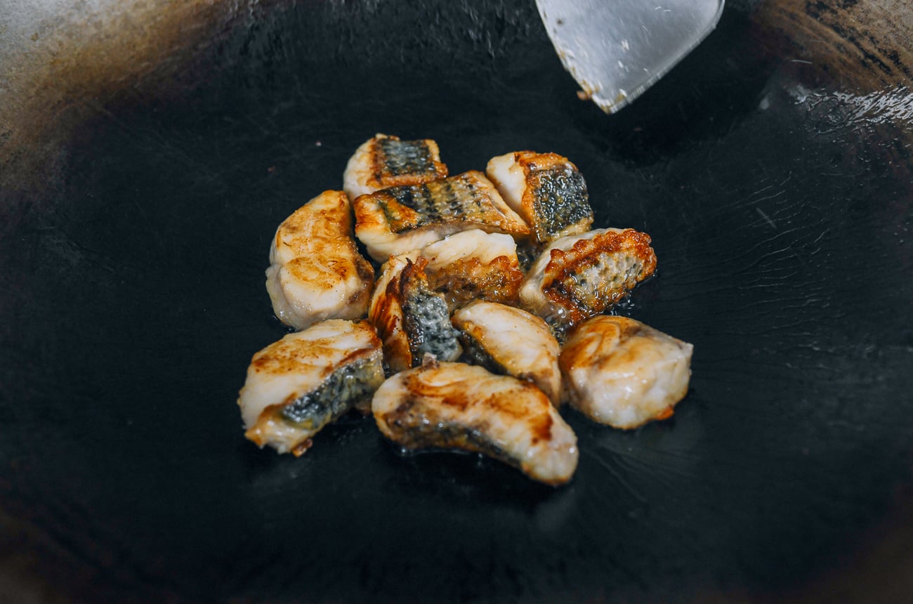 frying fish pieces in wok