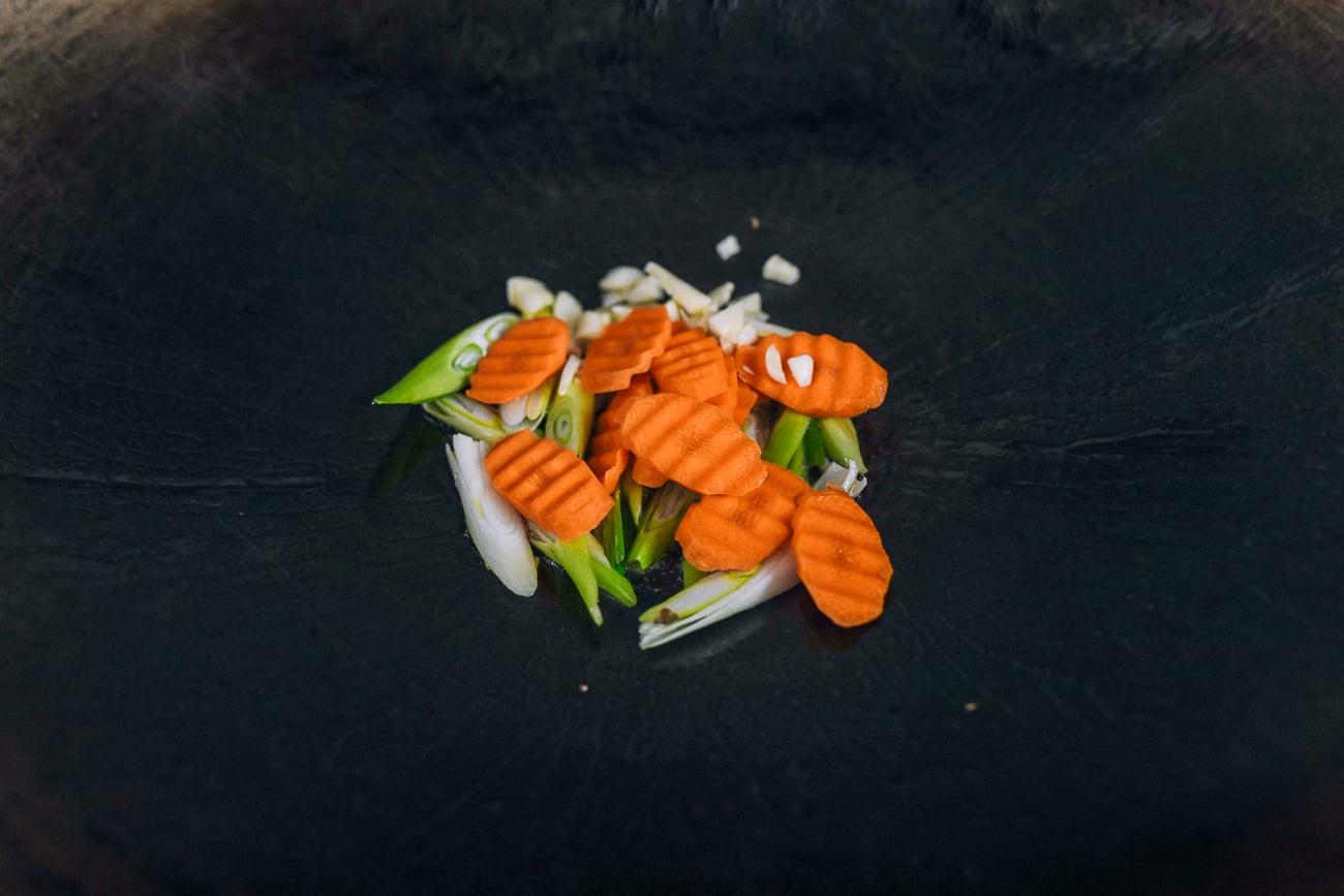 sliced carrots and garlic added to ginger and scallions