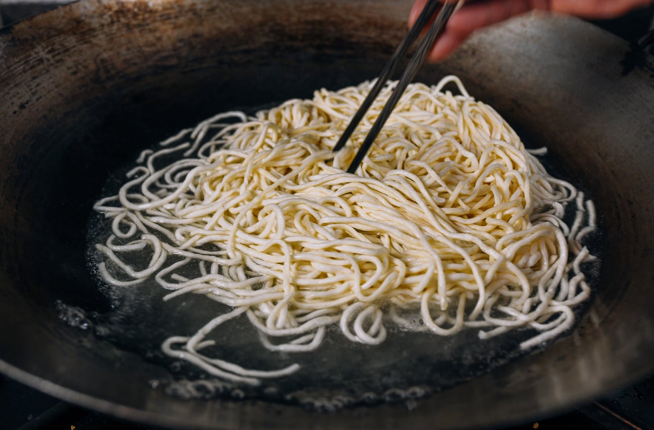 breaking up yee mein in boiling water