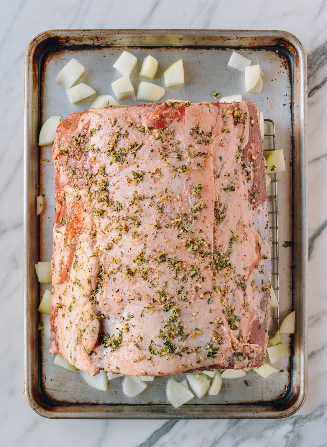 marinated prime rib on rack on sheet pan with onions