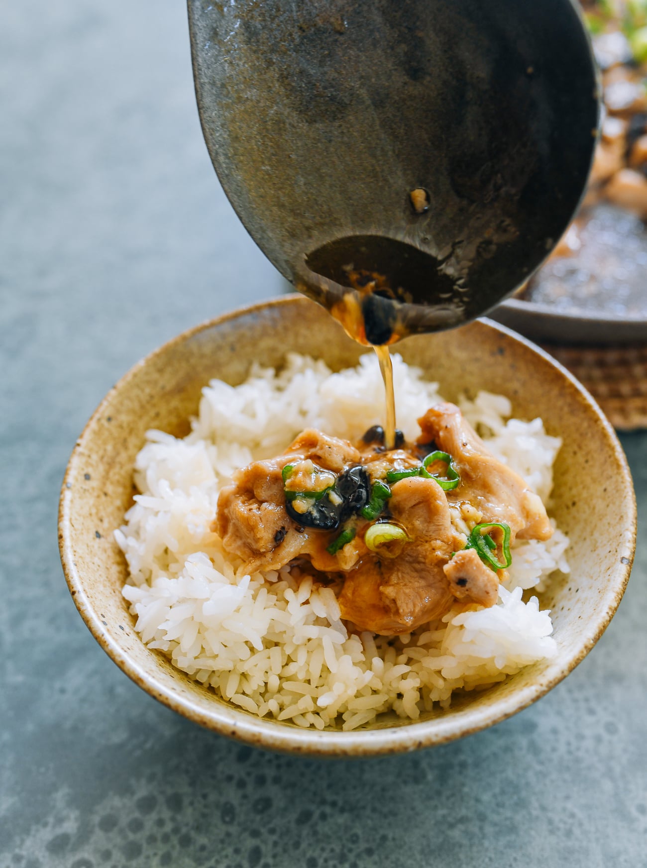 pouring sauce over Chinese steamed chicken with fermented black bean