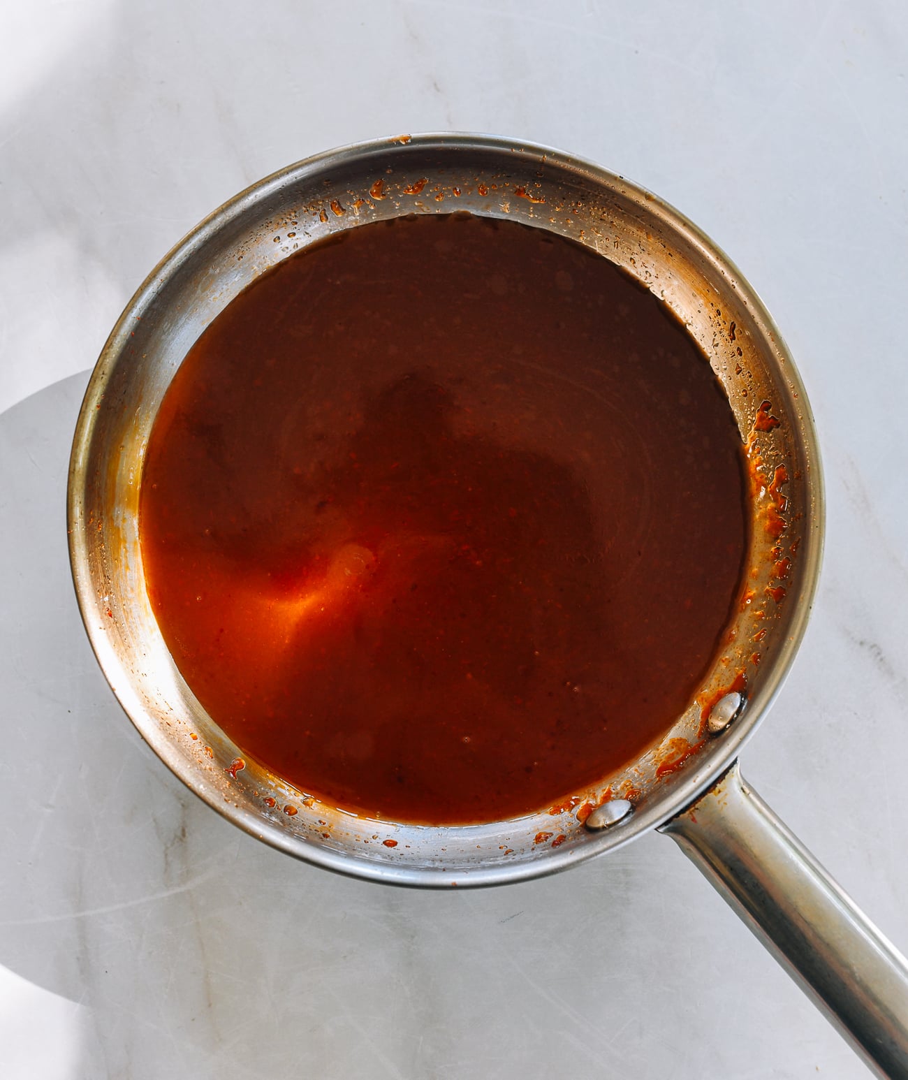 non-reactive saucepan filled with sweet and sour sauce