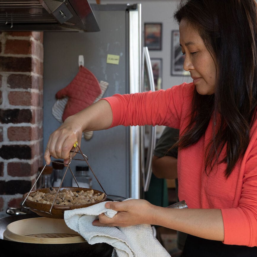 Using a plate lifter to remove hot dish from steaming in wok