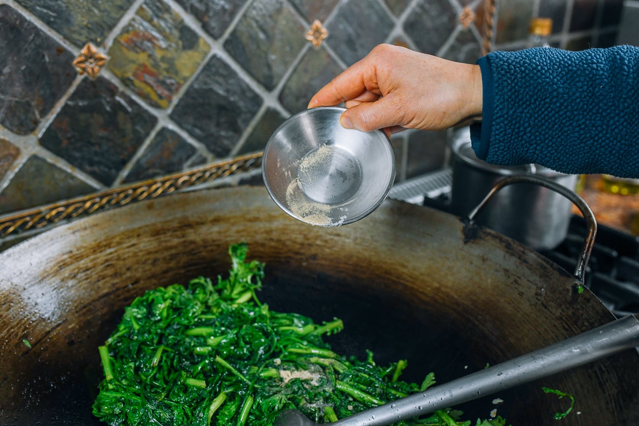 adding white pepper to tong ho in wok