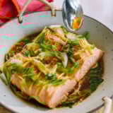 pouring sauce over steamed salmon fillet