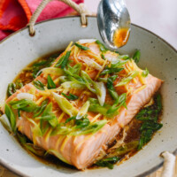 pouring sauce over steamed salmon fillet