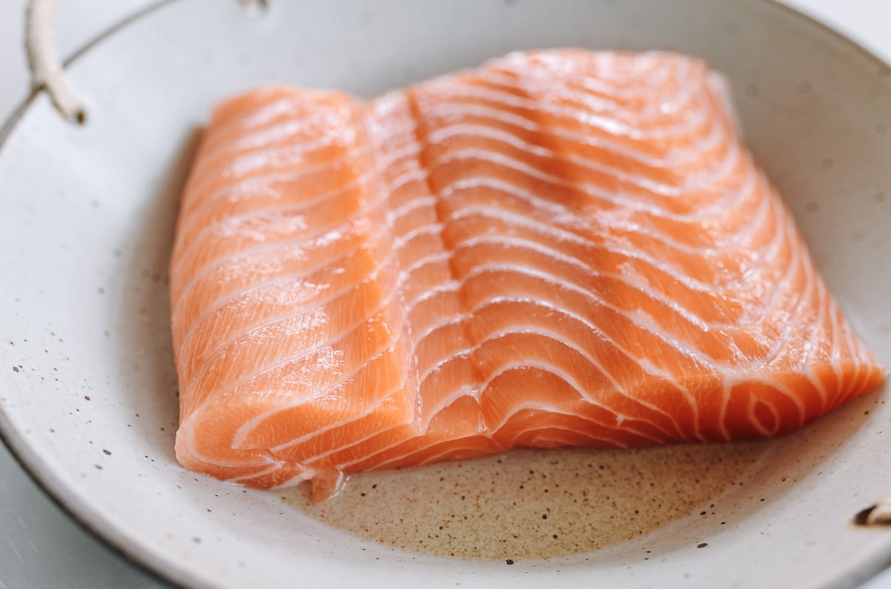 tucking belly portion of salmon under the rest fo the fillet to create an even thickness
