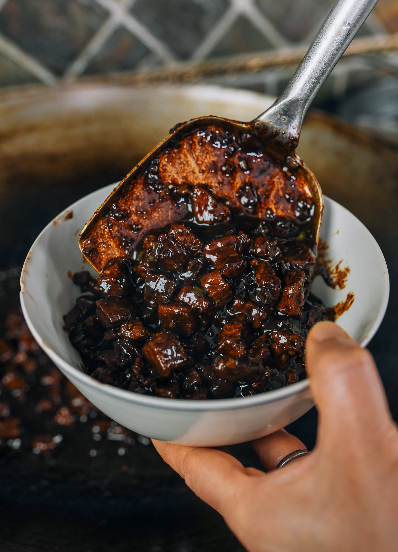 putting zha jiang mian sauce into bowl with metal wok spatula