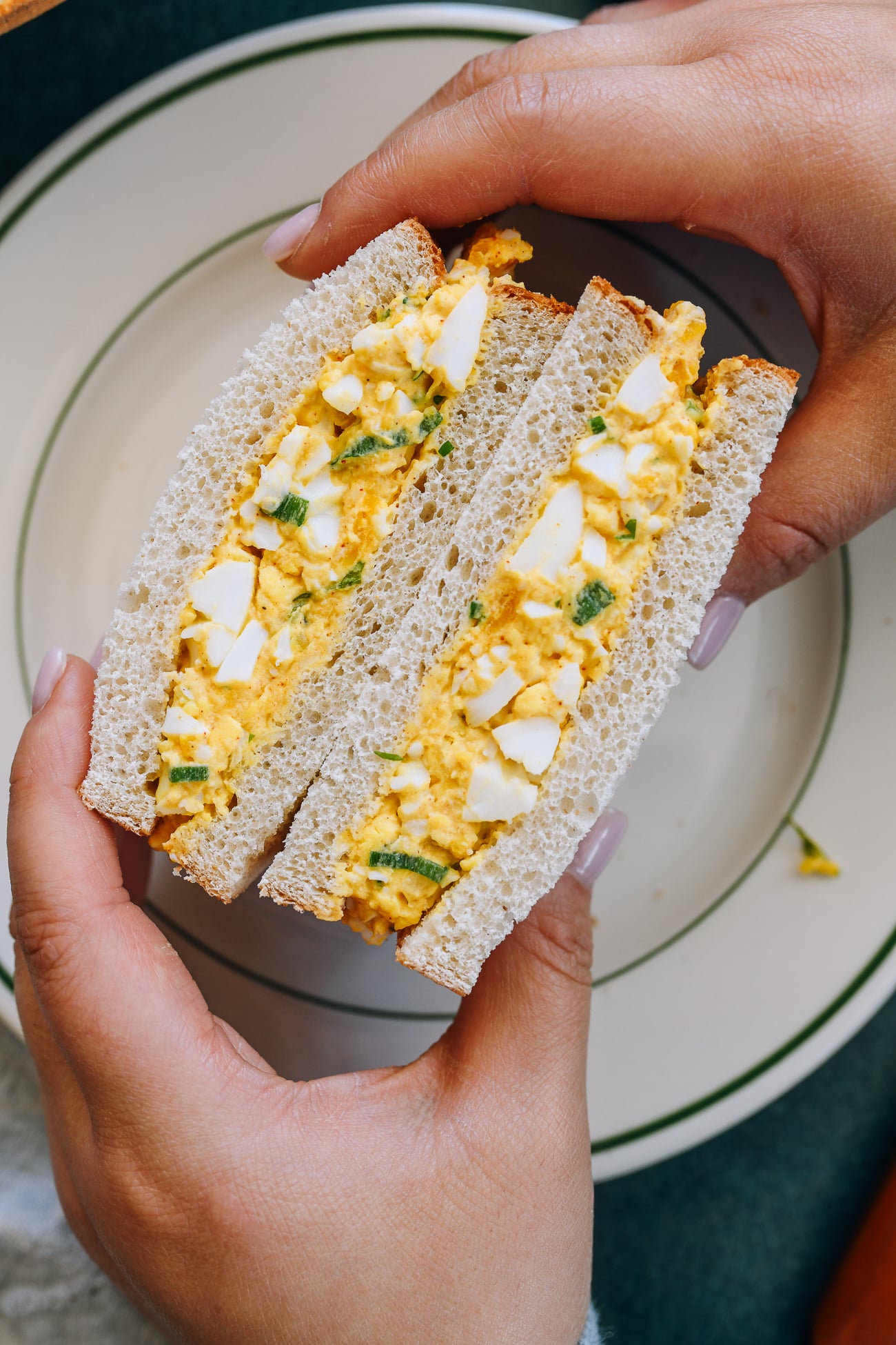 holding Egg Salad Sandwich halves