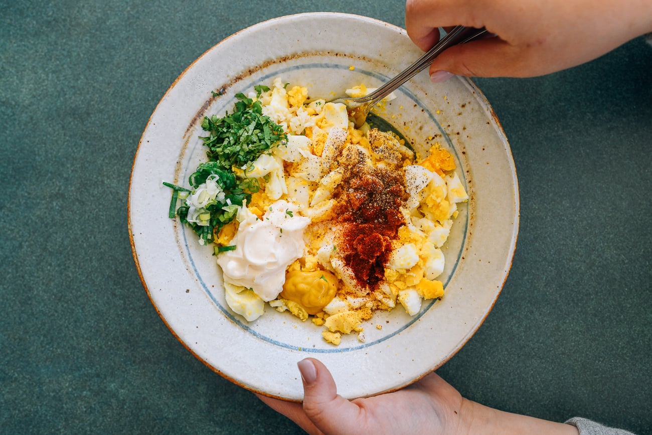 Mixing egg salad ingredients in a bowl