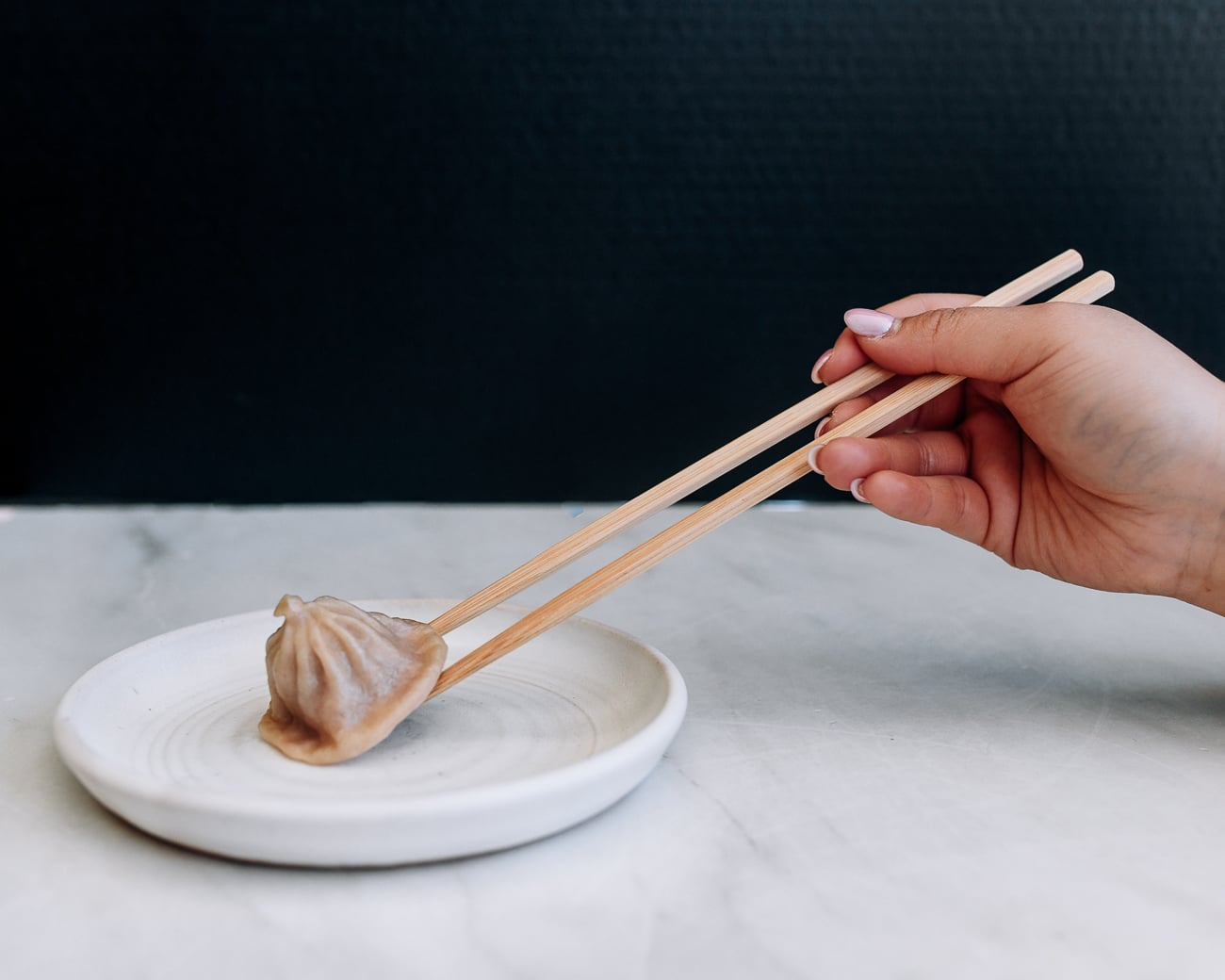 tucking chopsticks under dumpling to pick it up